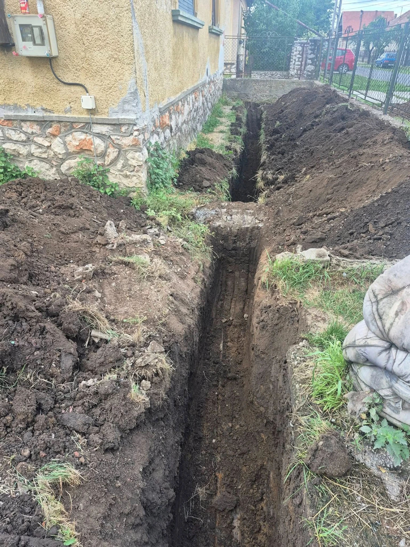 Minikotró tereprendezés közben egy szűk udvari területen